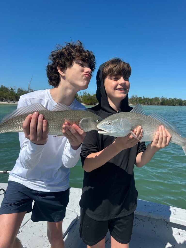 Boys Holding Redfish on Punta Gorda Family Fun Fishing Charter Two kids holding redfish during a fun family fishing charter in Punta Gorda, Florida