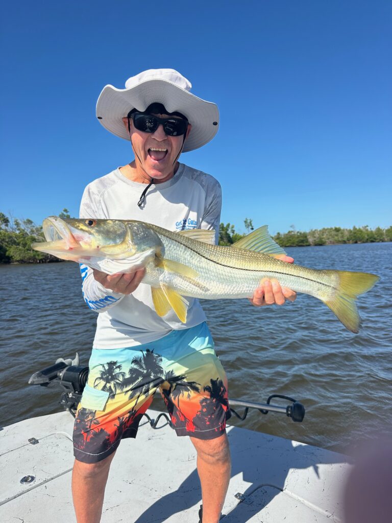Punta Gorda Snook Fishing Charter – ReelFishing Charters Angler smiling and holding a large Snook aboard a ReelFishing Charters boat during a Punta Gorda fishing charter with Captain Danny Latham