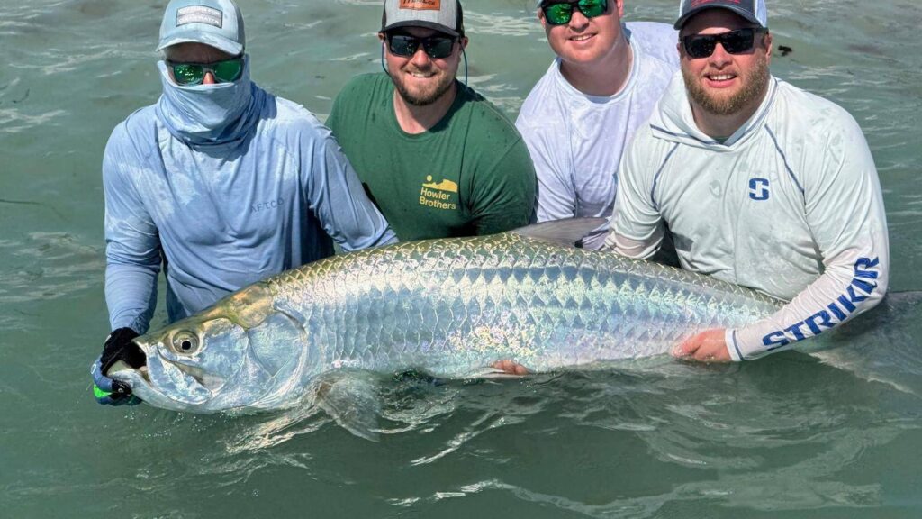 Boca Grande Tarpon Fishing Charter – Trophy Tarpon Catch Anglers holding a trophy tarpon during a Boca Grande tarpon fishing charter with ReelFishing Charters
