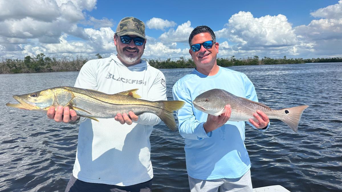 Two anglers holding Snook and Redfish on an inshore fishing charter in Boca Grande and Punta Gorda, Florida