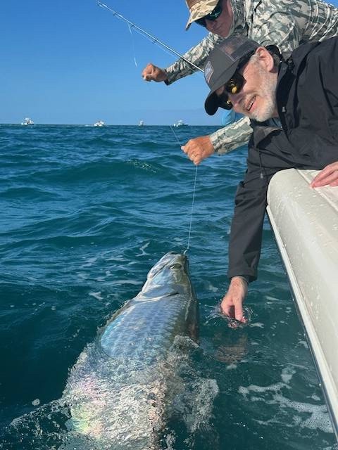 Boca Grande Tarpon Charter Action Anglers fighting and releasing tarpon in Boca Grande Florida with multiple boats in background
