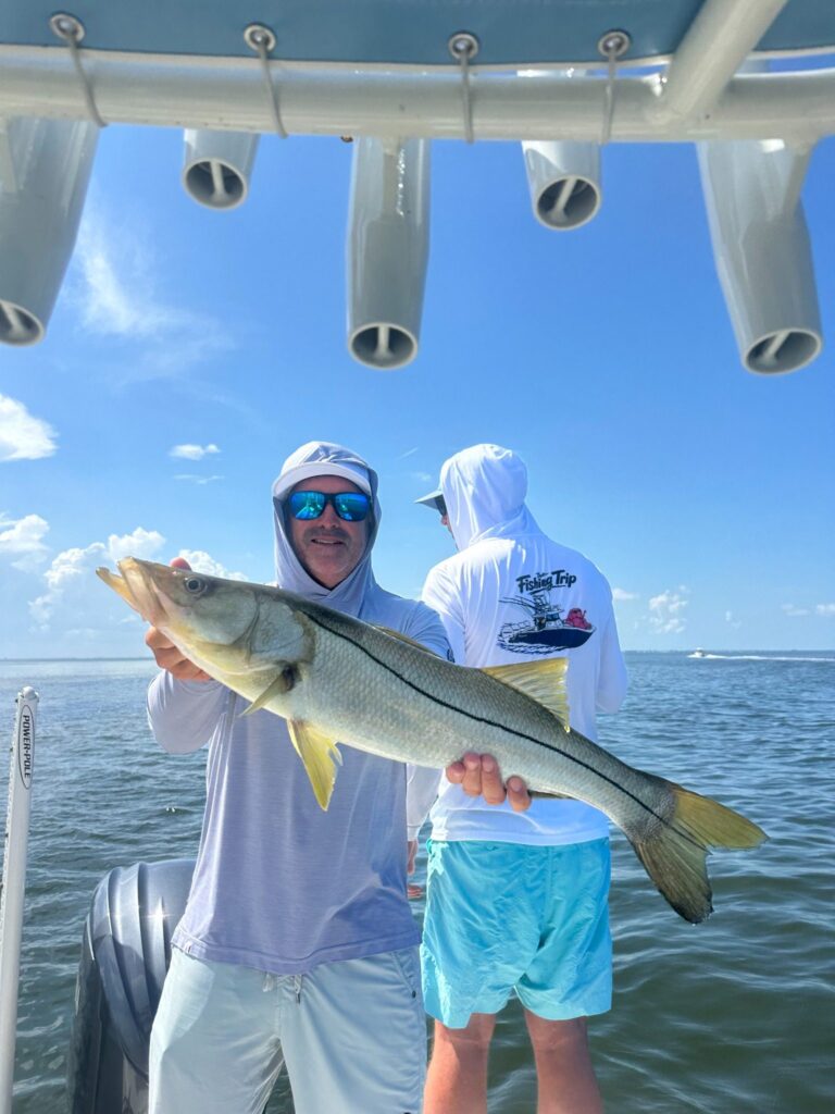 July Snook Fishing in Punta Gorda & Charlotte Harbor Angler holding a healthy snook caught during a July fishing charter near Punta Gorda and Charlotte Harbor, Florida.