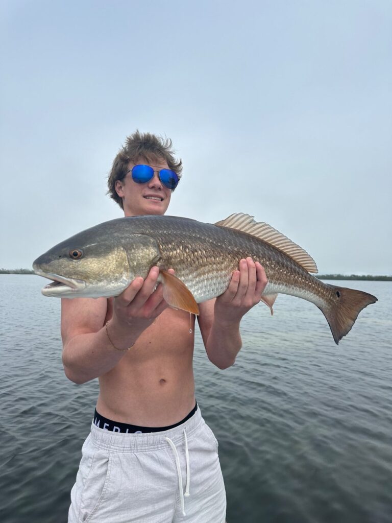 Fall Redfish Fishing in Charlotte Harbor Angler holding a large redfish during a fall fishing charter in Charlotte Harbor