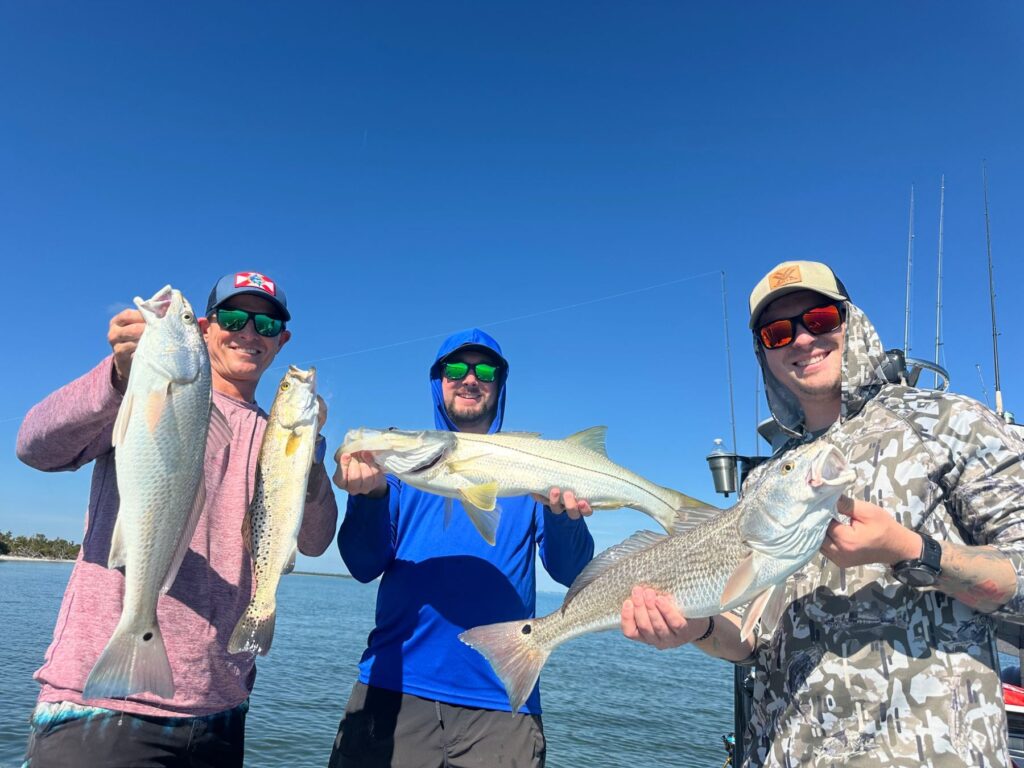Fall Inshore Fishing in Southwest Florida Three anglers displaying redfish, snook and speckled trout caught during a Southwest Florida fishing charter