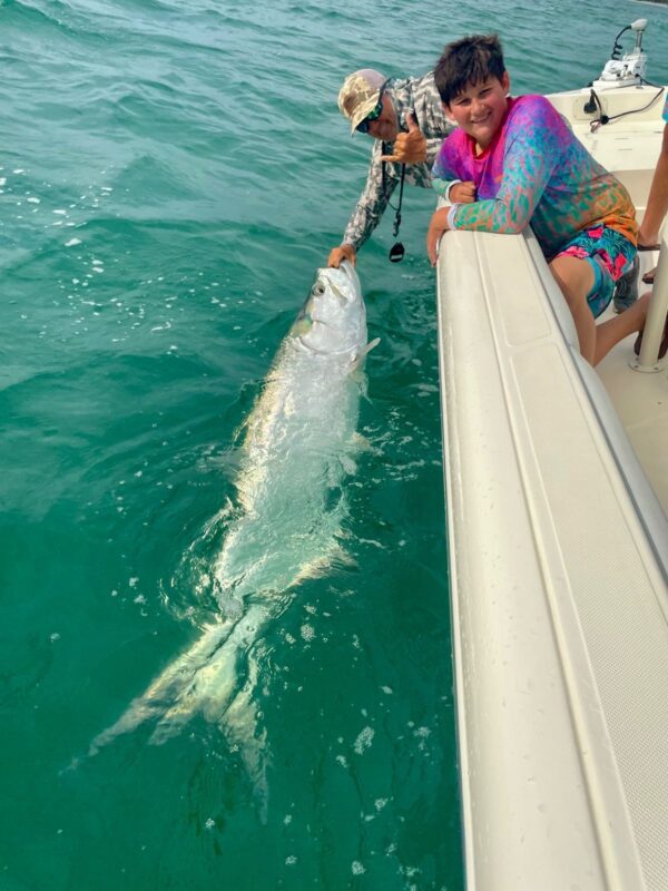 Family Tarpon Fishing Charter in Charlotte Harbor Young angler with Captain Danny and a Tarpon during a Charlotte Harbor fishing charter