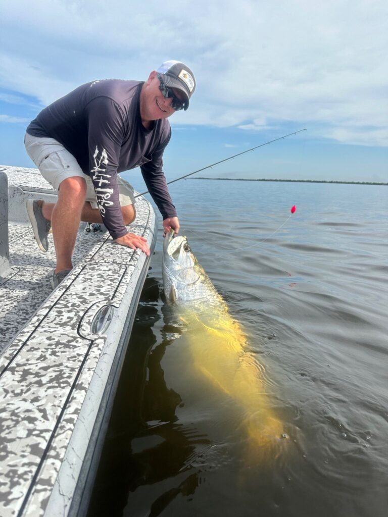 Fall Tarpon Fishing – Charlotte Harbor Florida Angler boatside with a tarpon during fall tarpon fishing in Charlotte Harbor, Florida.